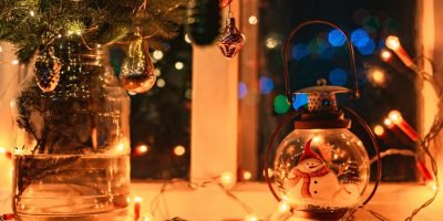 christmas decorations on the window at night, fir branches, retro glass decorations, lights garlands